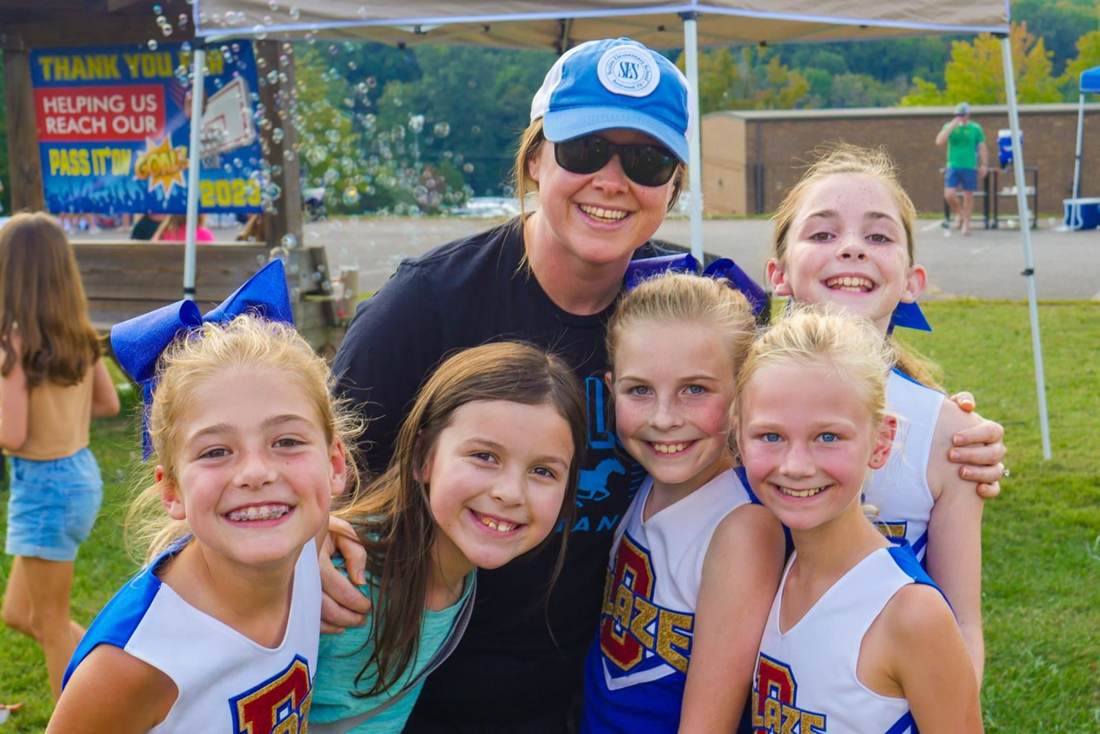 teacher with students in cheer outfits